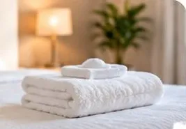 Fresh white towels on a made bed